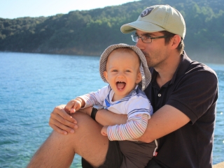 Papa et fils assis avec la vue sur la mer